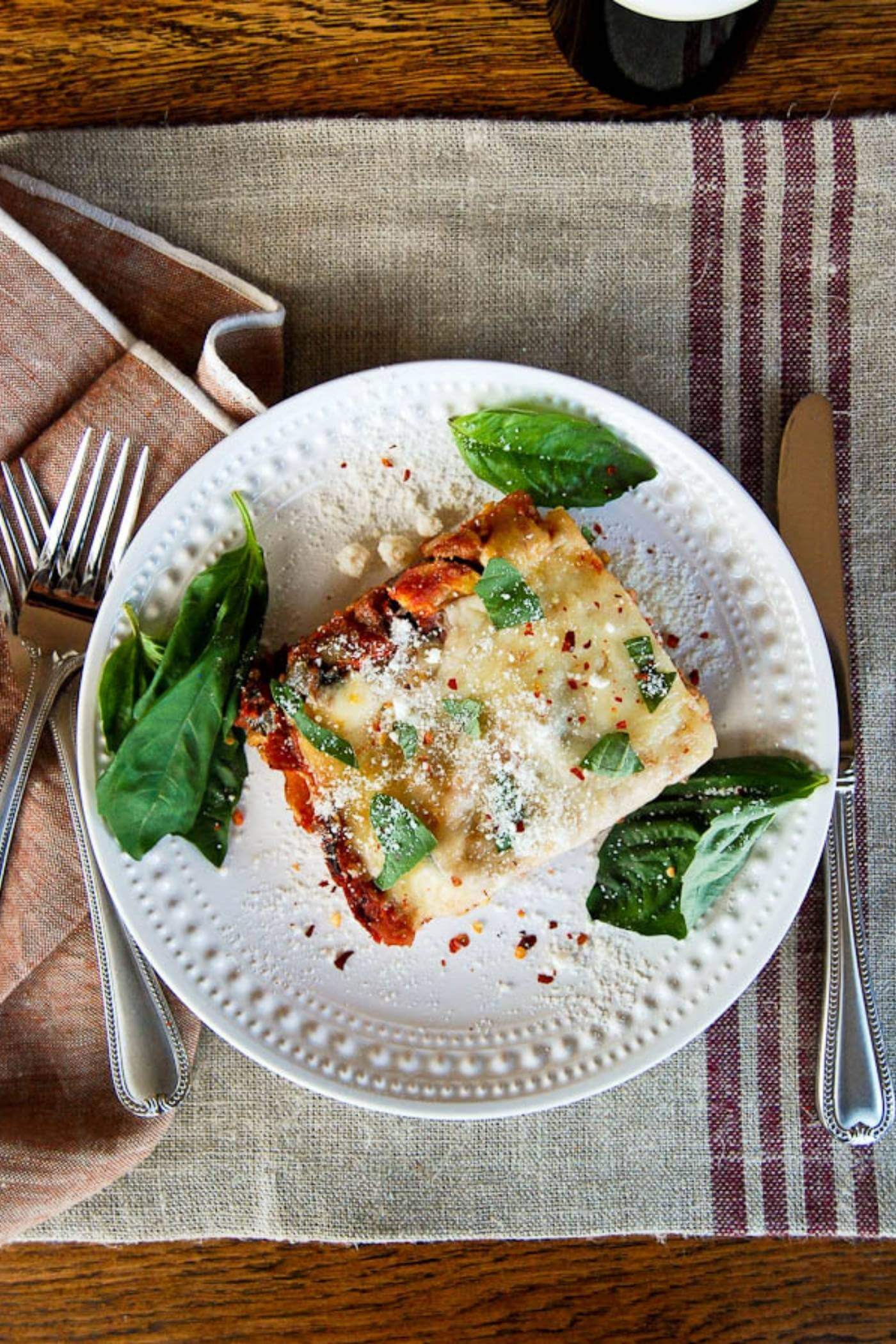 easy vegetable lasagna on plate with basil and parmesan.