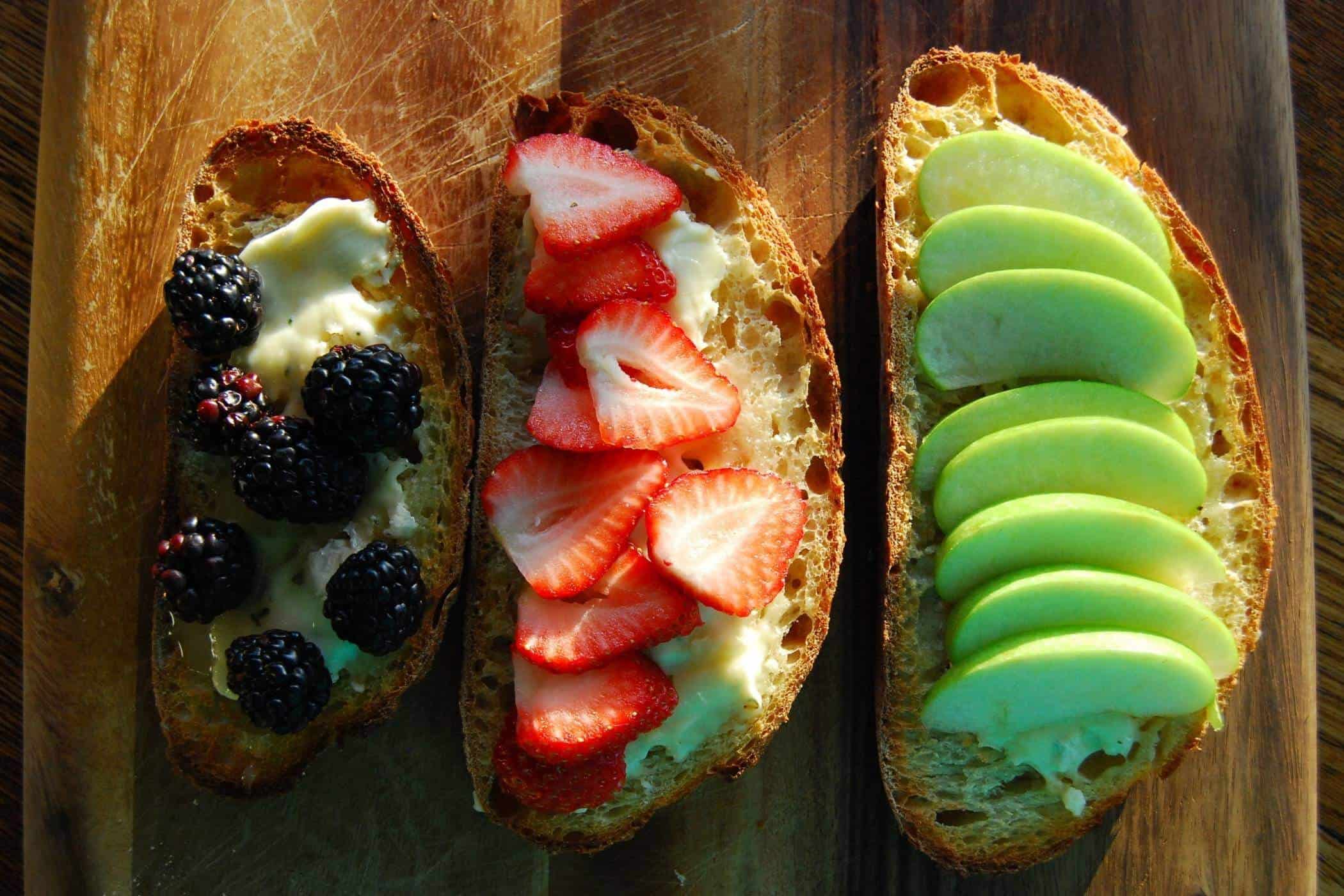 cheese fruit and honey bruschetta on cutting board.