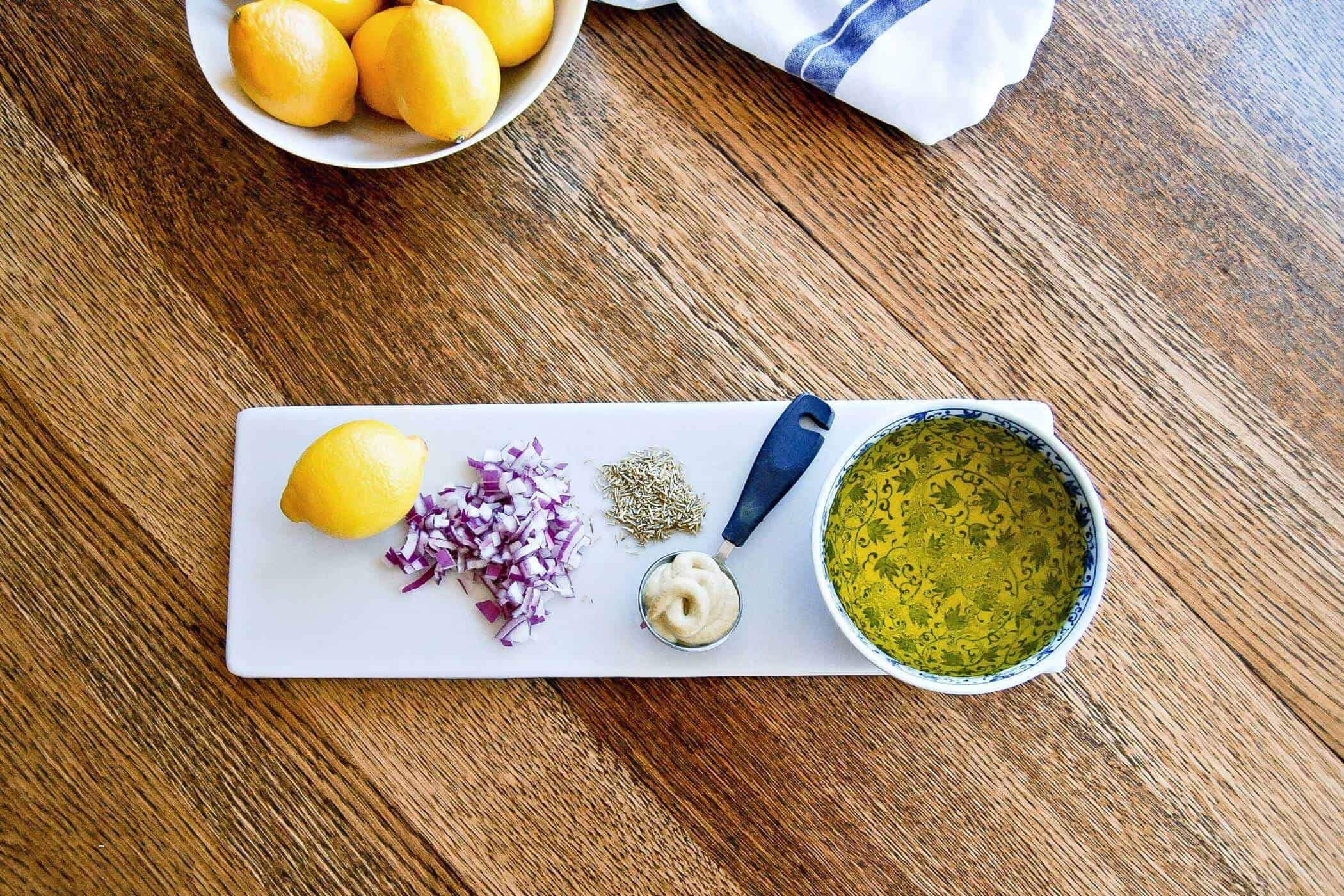 lemon and rosemary vinaigrette ingredients on table.