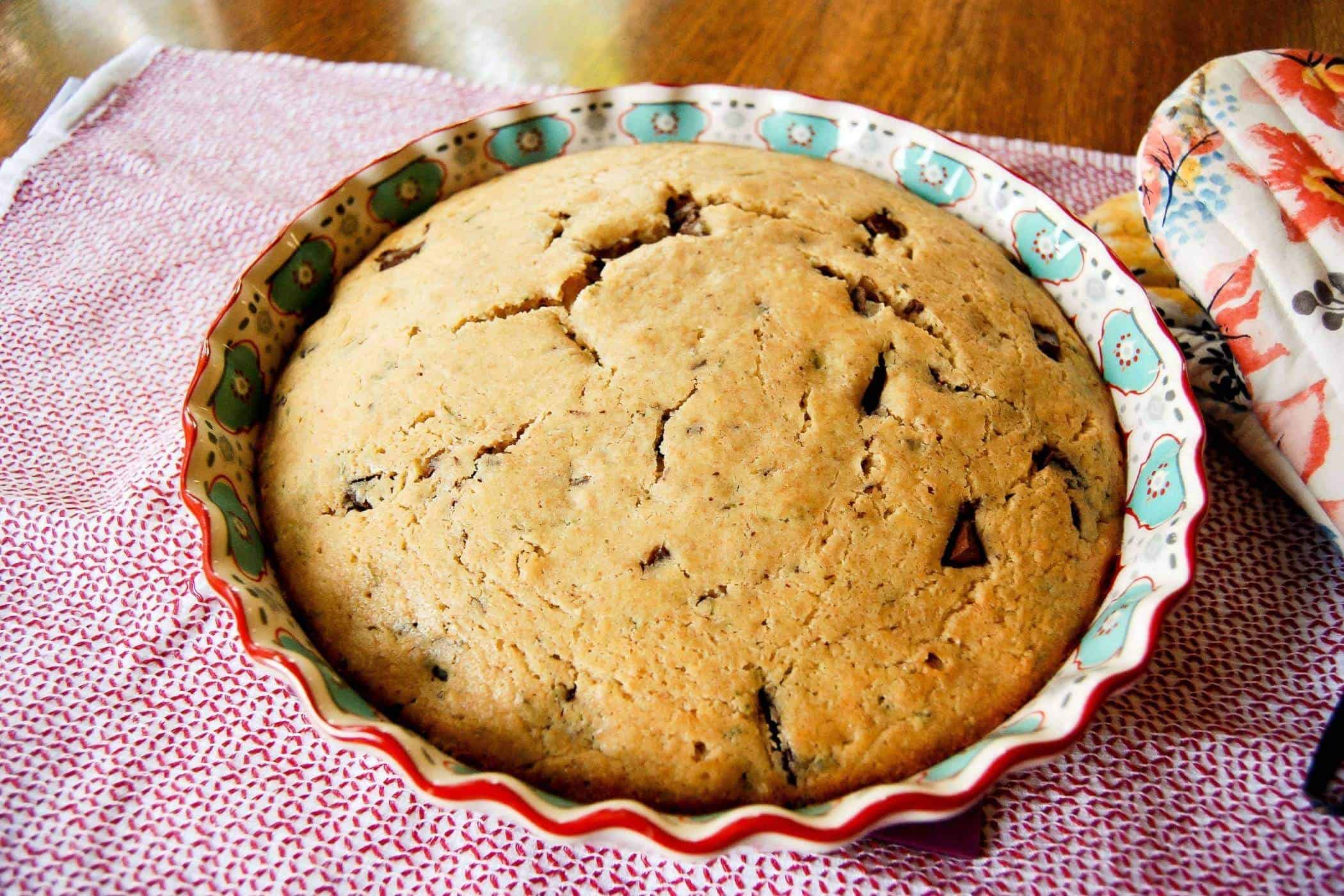 olive oil and rosemary cake with dark chocolate in baking dish on table.