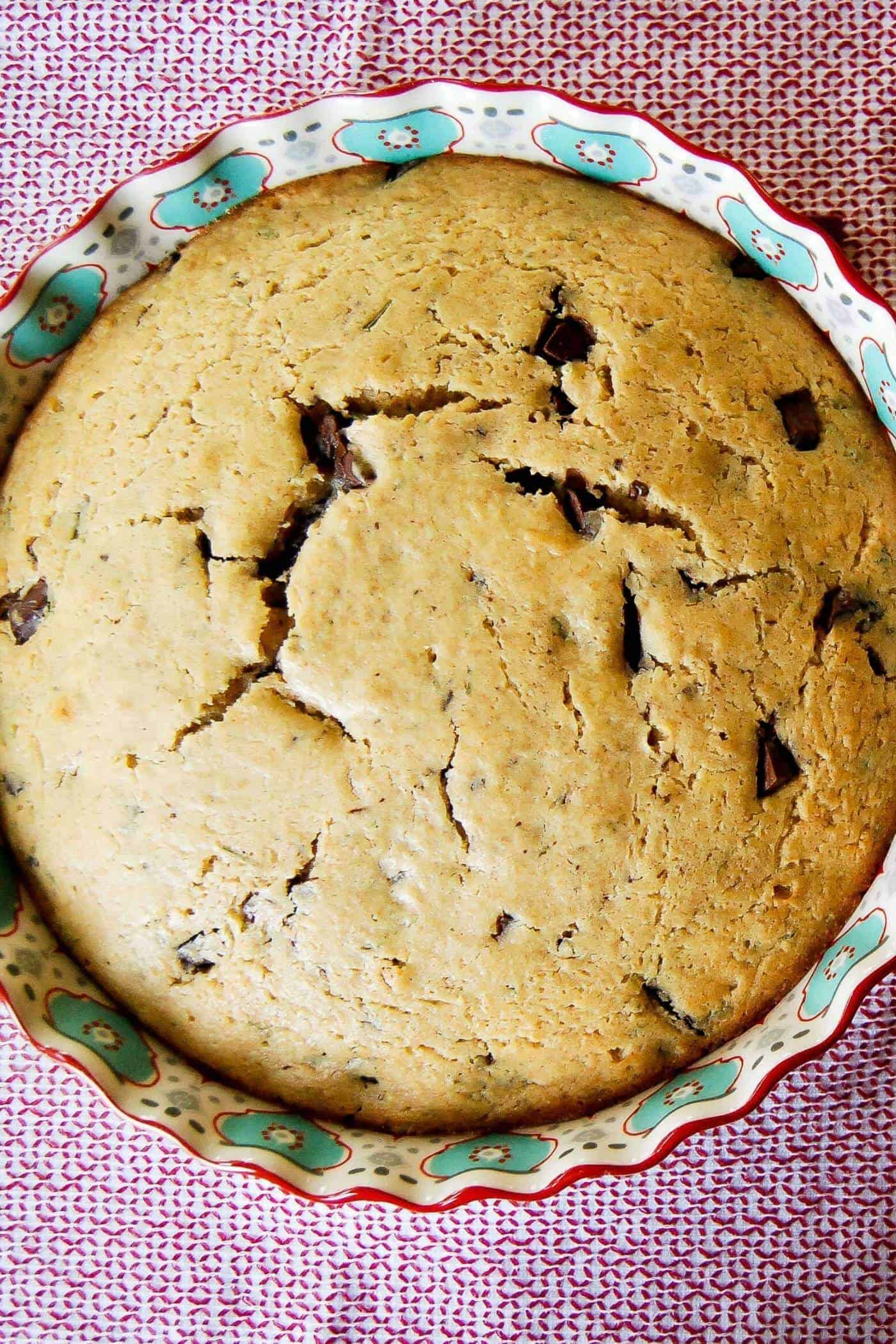 olive oil cake with rosemary and dark chocolate in baking dish.