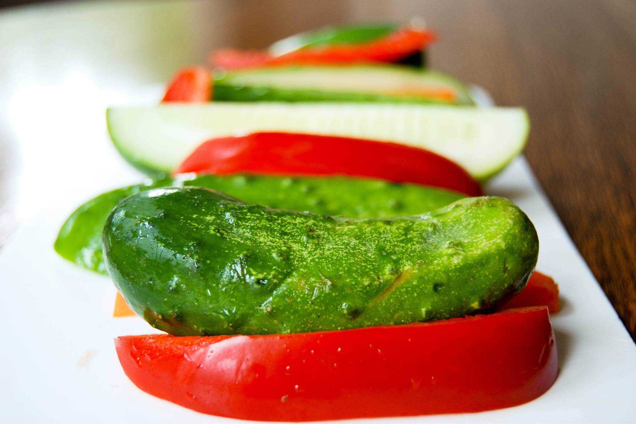 pickling cucumbers and peppers on cutting board.