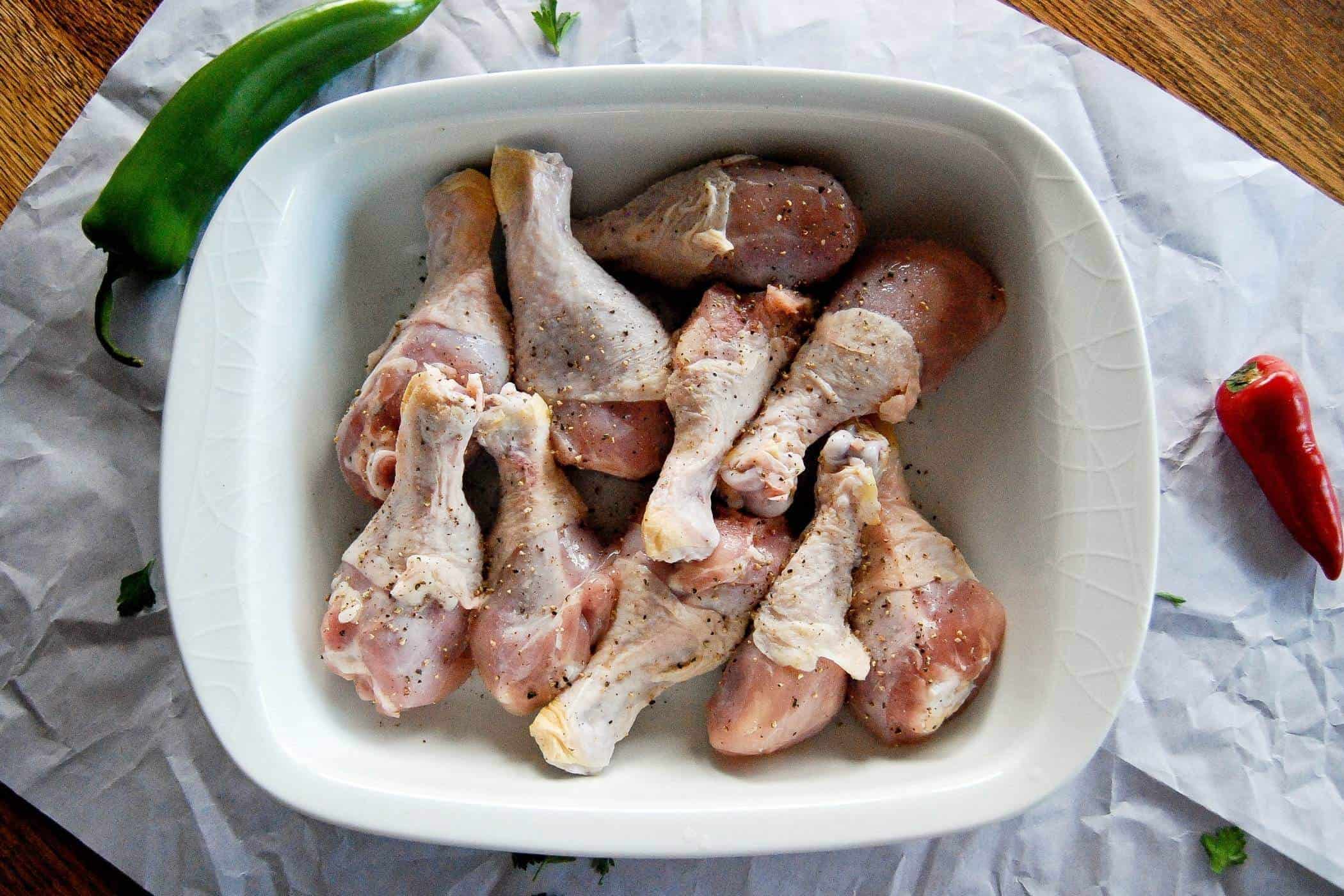 seasoned chicken drumsticks in baking dish.