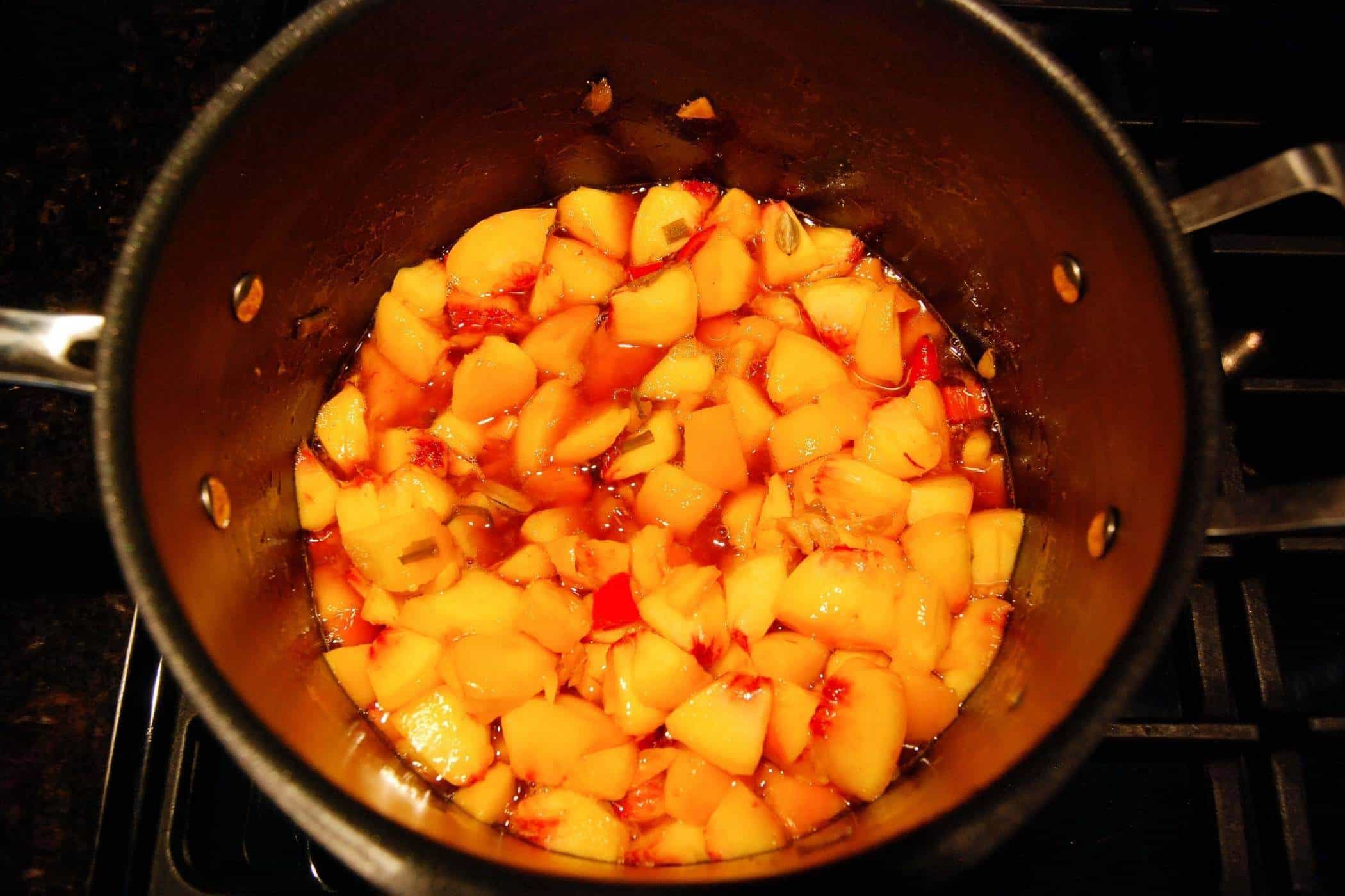 spicy peach chutney cooking on stovetop.