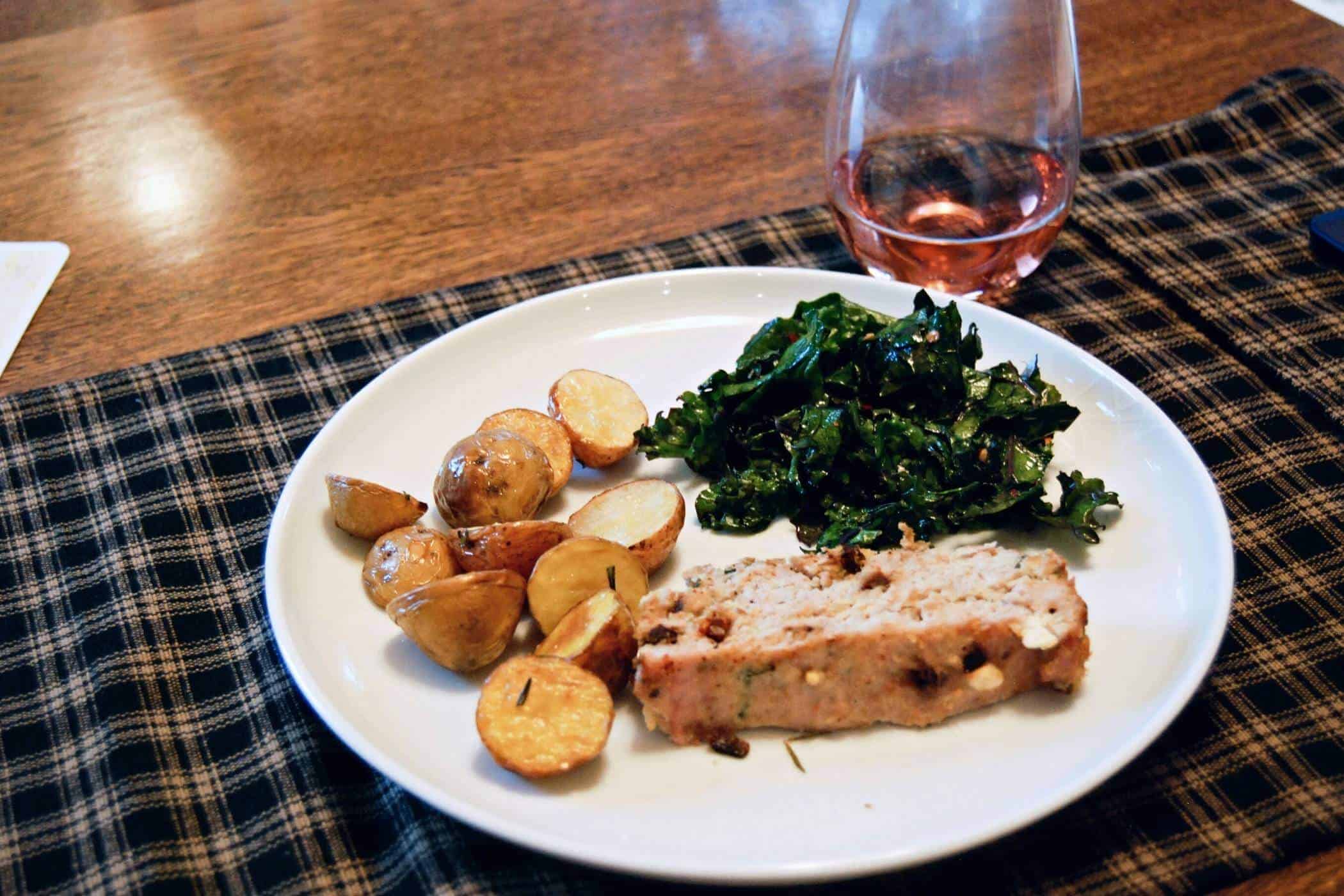 turkey meatloaf on plate with potatoes and cooked spinach.