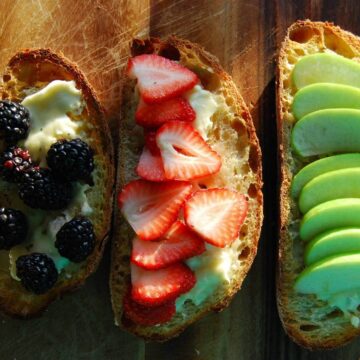 cheese fruit and honey bruschetta on cutting board.