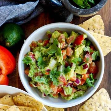 chunky guacamole in bowl with chips