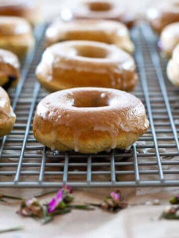 glazed cake donuts on cooling rack.