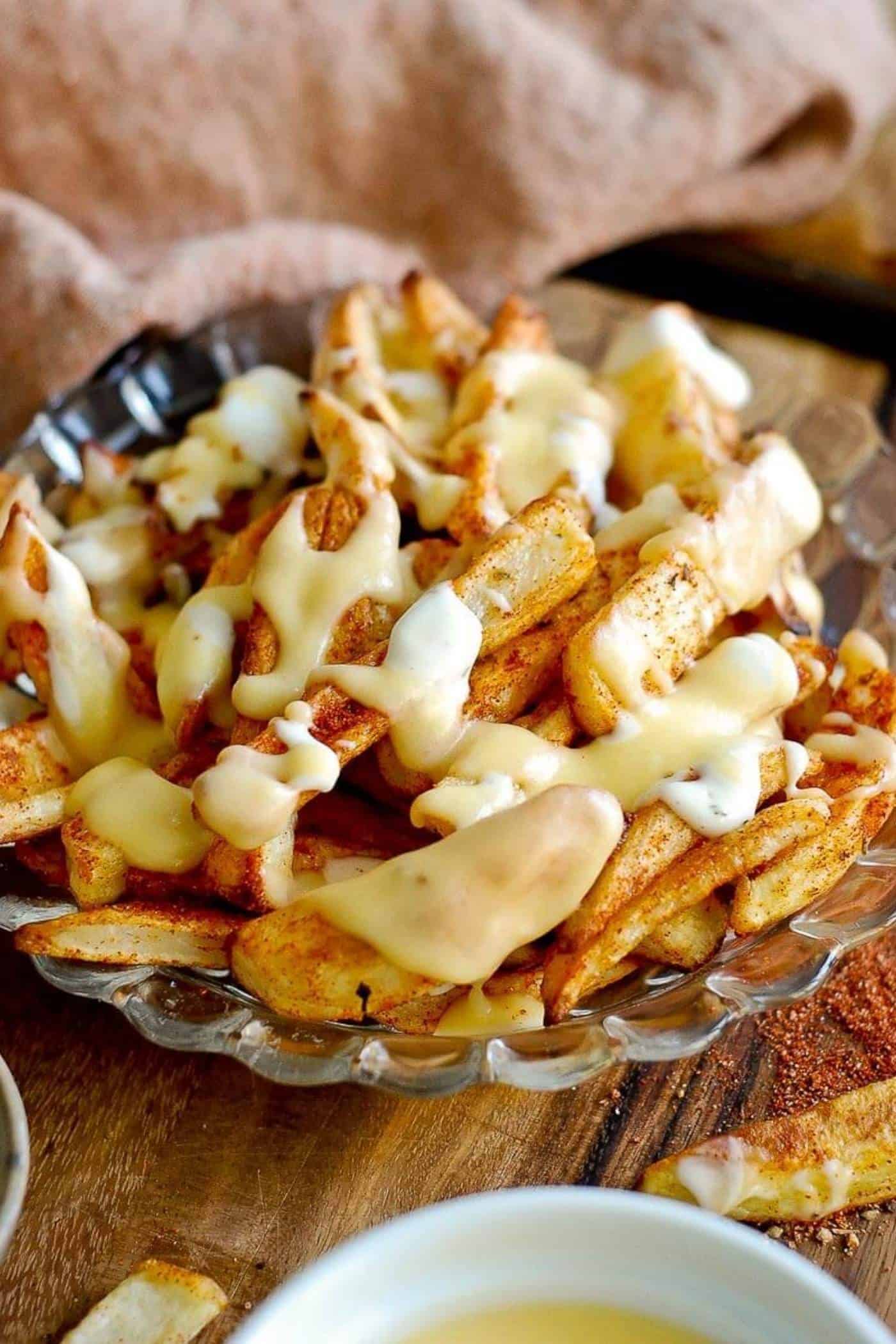 louisiana voodoo fries with cajun seasoning, ranch dressing and cheese sauce on plate.