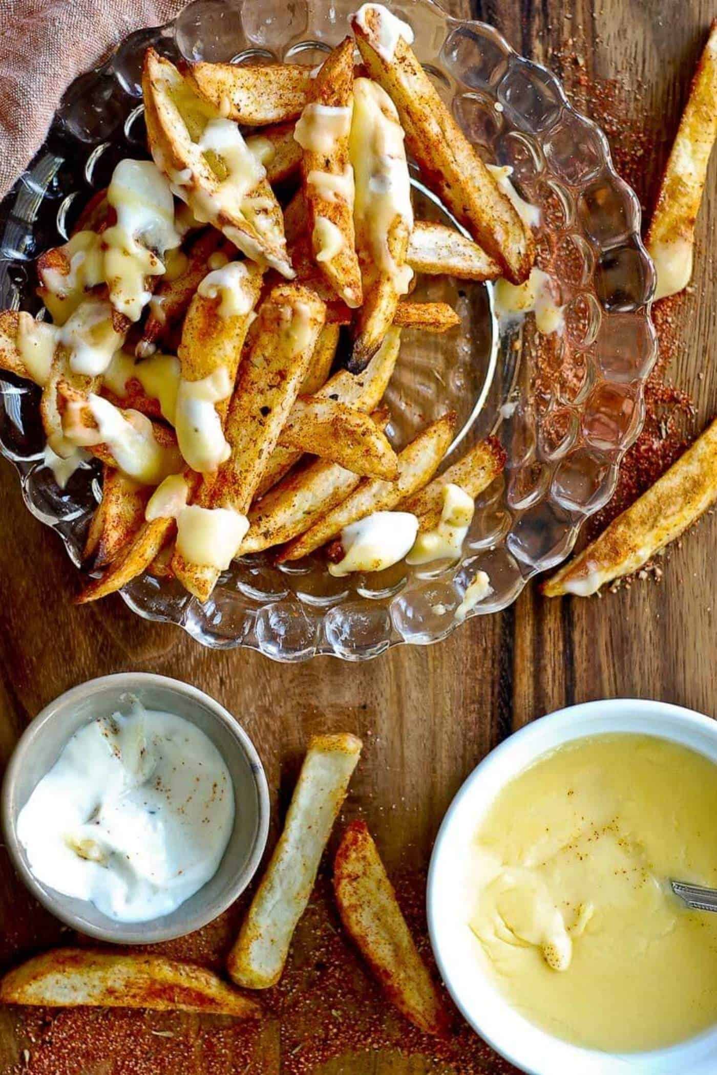 half eaten plate of louisiana voodoo fries with cajun seasoning, ranch dressing and cheese sauce.