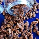 maple spiced roasted walnuts spilling out of jar.