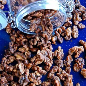 maple spiced roasted walnuts spilling out of jar.