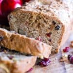 apple cranberry and walnut quick bread on cutting board.