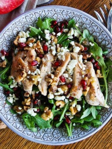 chicken pomegranate and arugula crunch salad in bowl.