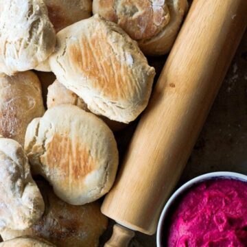 pita bread next to rolling pin and beet root hummus