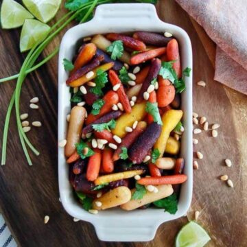 hot honey roasted carrots with pine nuts in casserole dish
