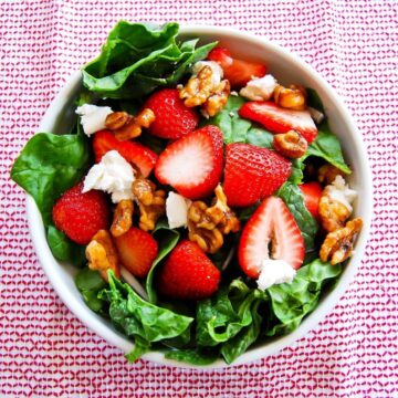 spinach strawberry and goat cheese salad in bowl.