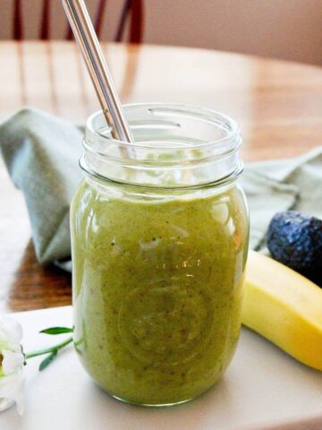 avocado pineapple smoothie in mason jar with straw