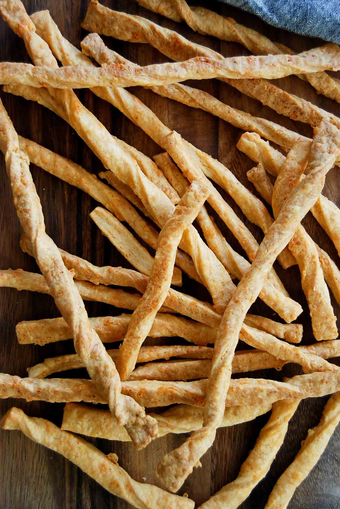 baked cheddar cheese straws on serving board.