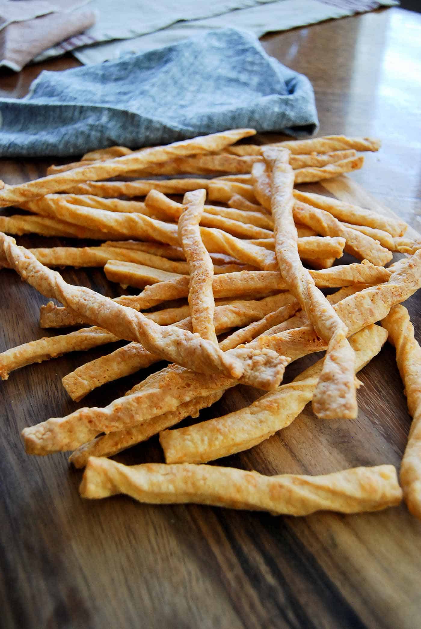 baked cheddar cheese straws on serving board.