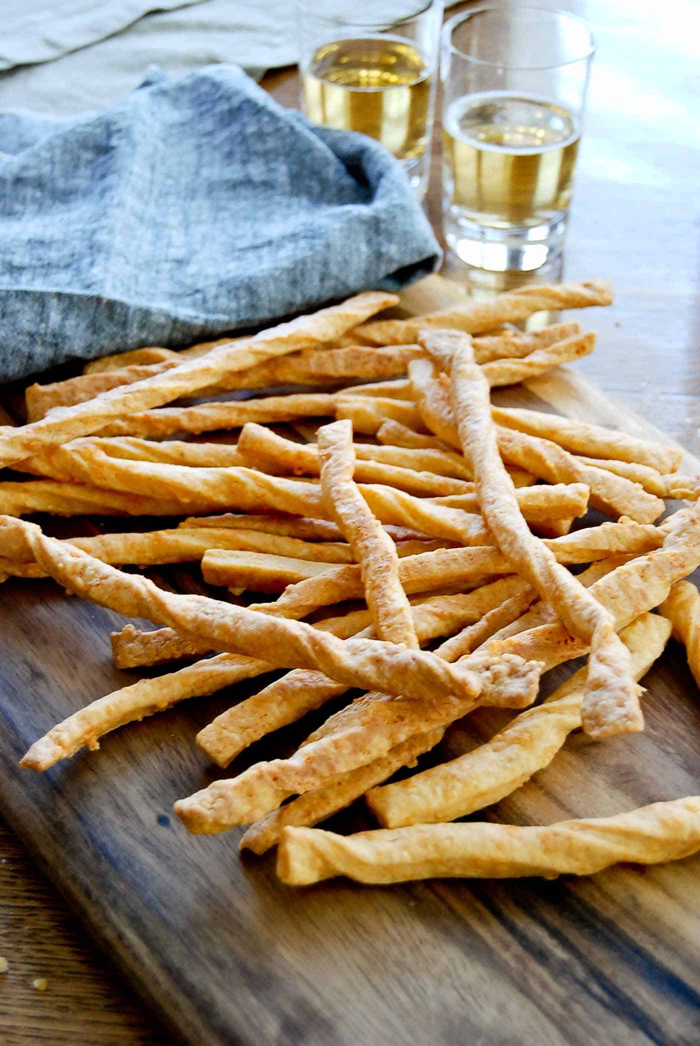 baked cheddar cheese straws on cutting board.