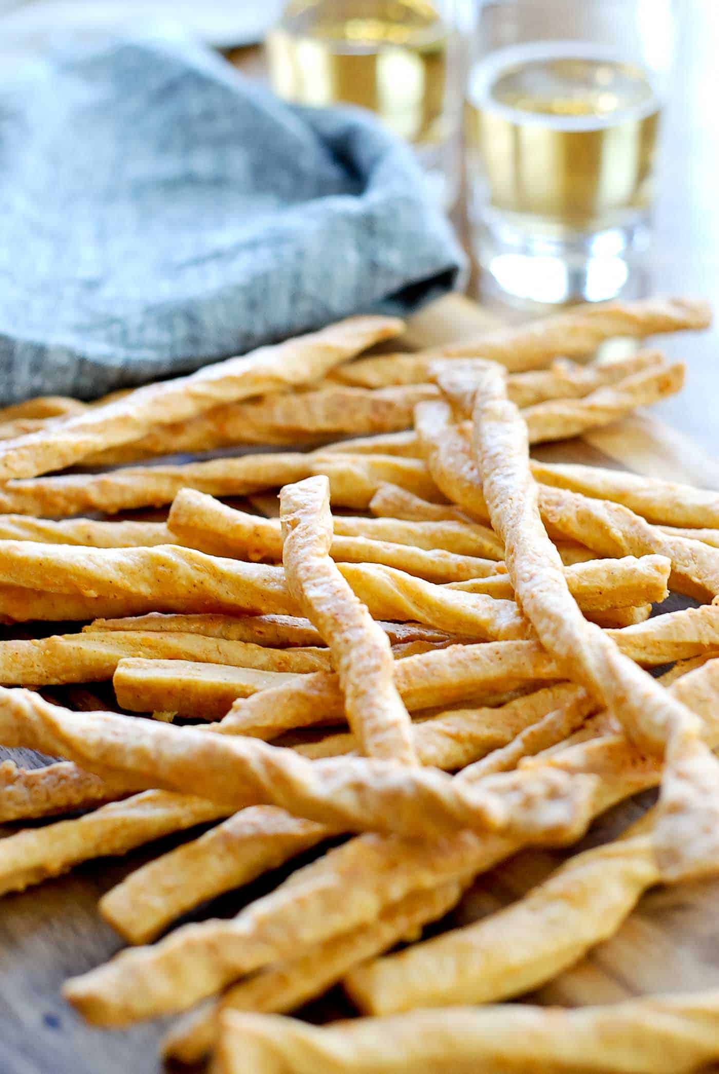 baked cheddar cheese straws on cutting board.