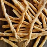 cheddar cheese straws on serving board.
