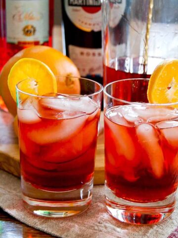 negronis in glasses garnished with orange slices.