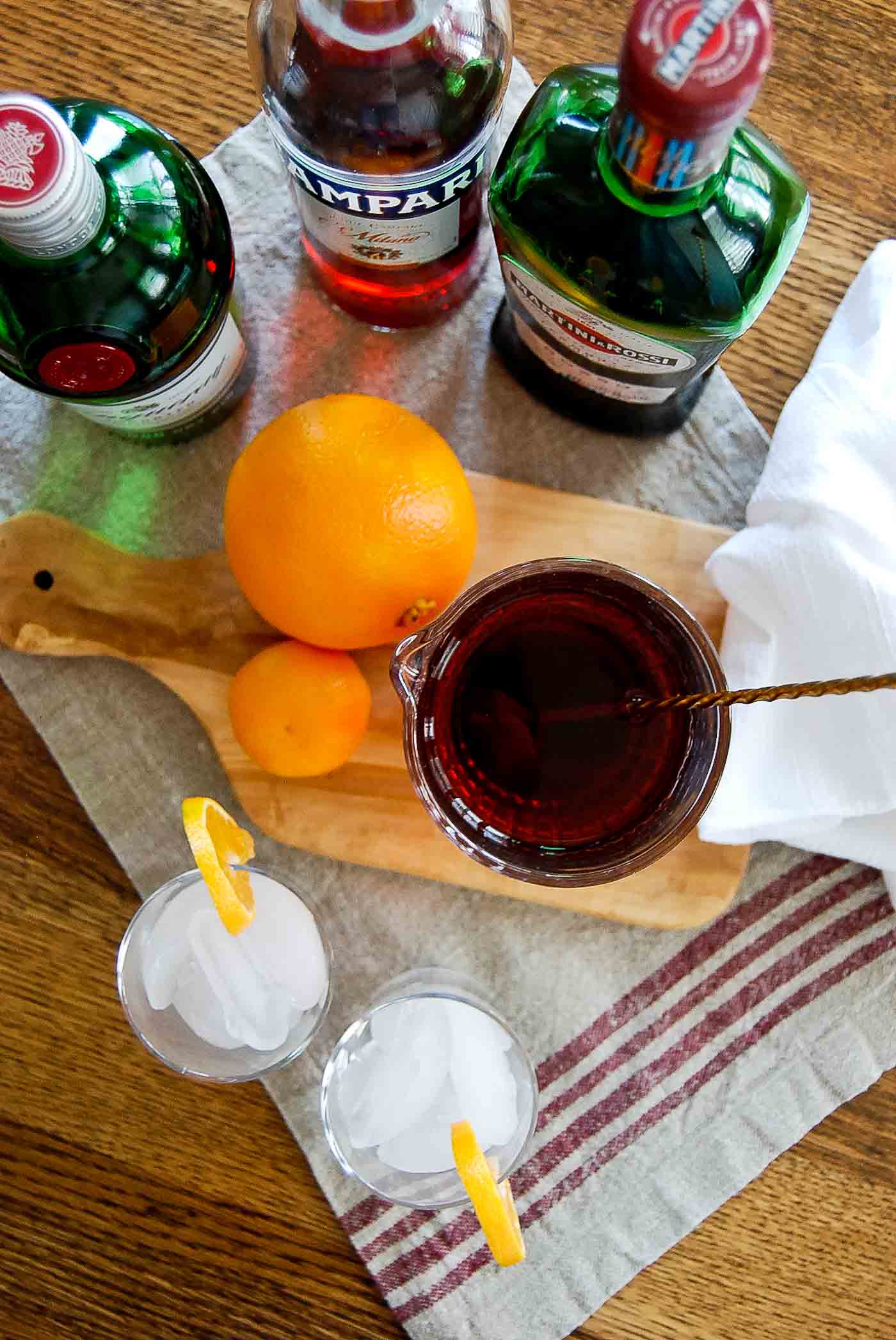 mixed negroni in pitcher, top down view with oranges and ingredients.