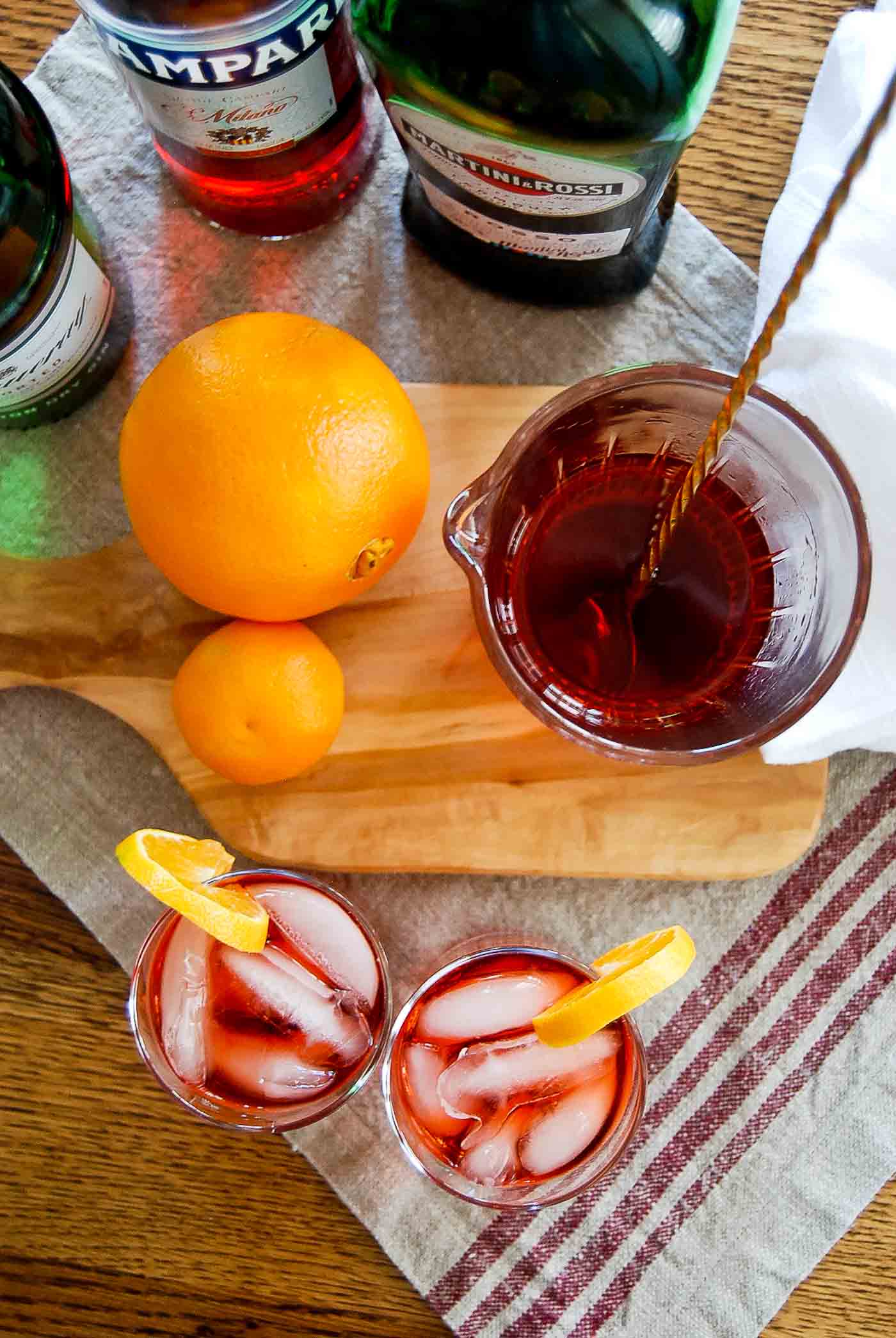 mixed negronis in pitcher and glasses, top down view.