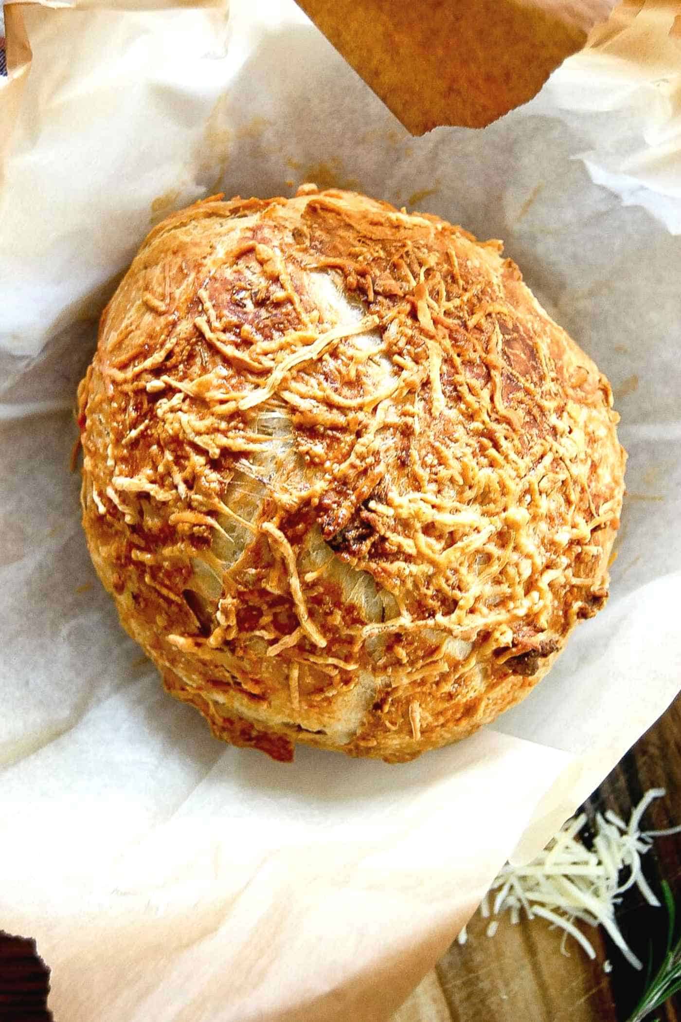 freshly baked rosemary parmesan bread on parchment paper.