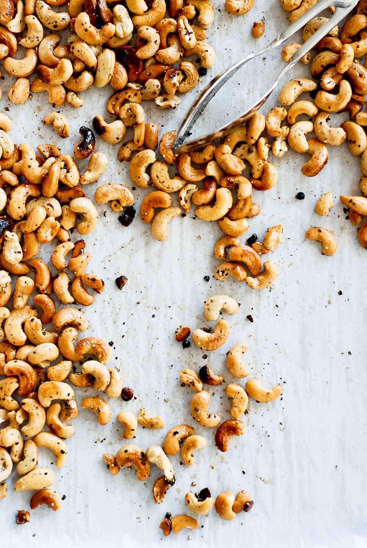 salt and pepper cashews on baking tray.