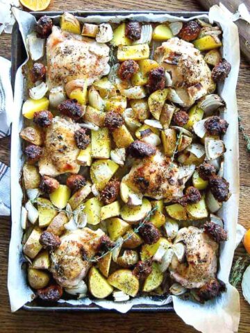 sheet pan chicken thighs, with sausage, potatoes and onions.