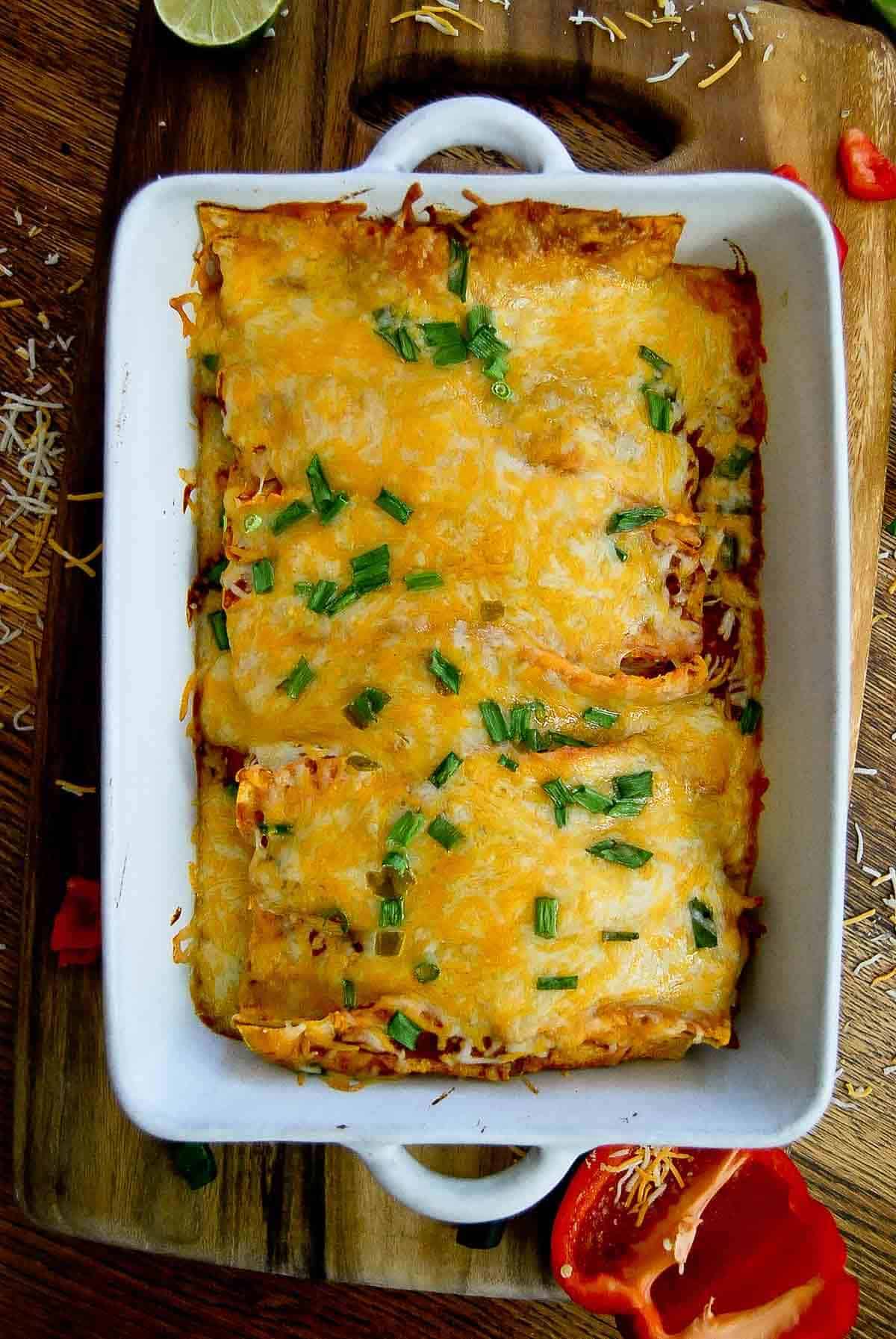 baked cheesy chicken enchiladas in baking dish.