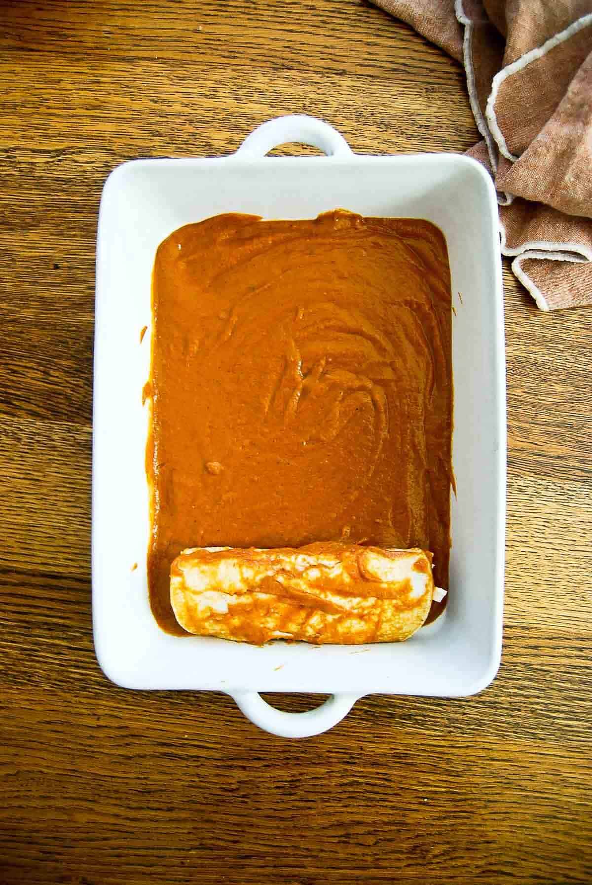 assembling chicken enchiladas in baking dish.