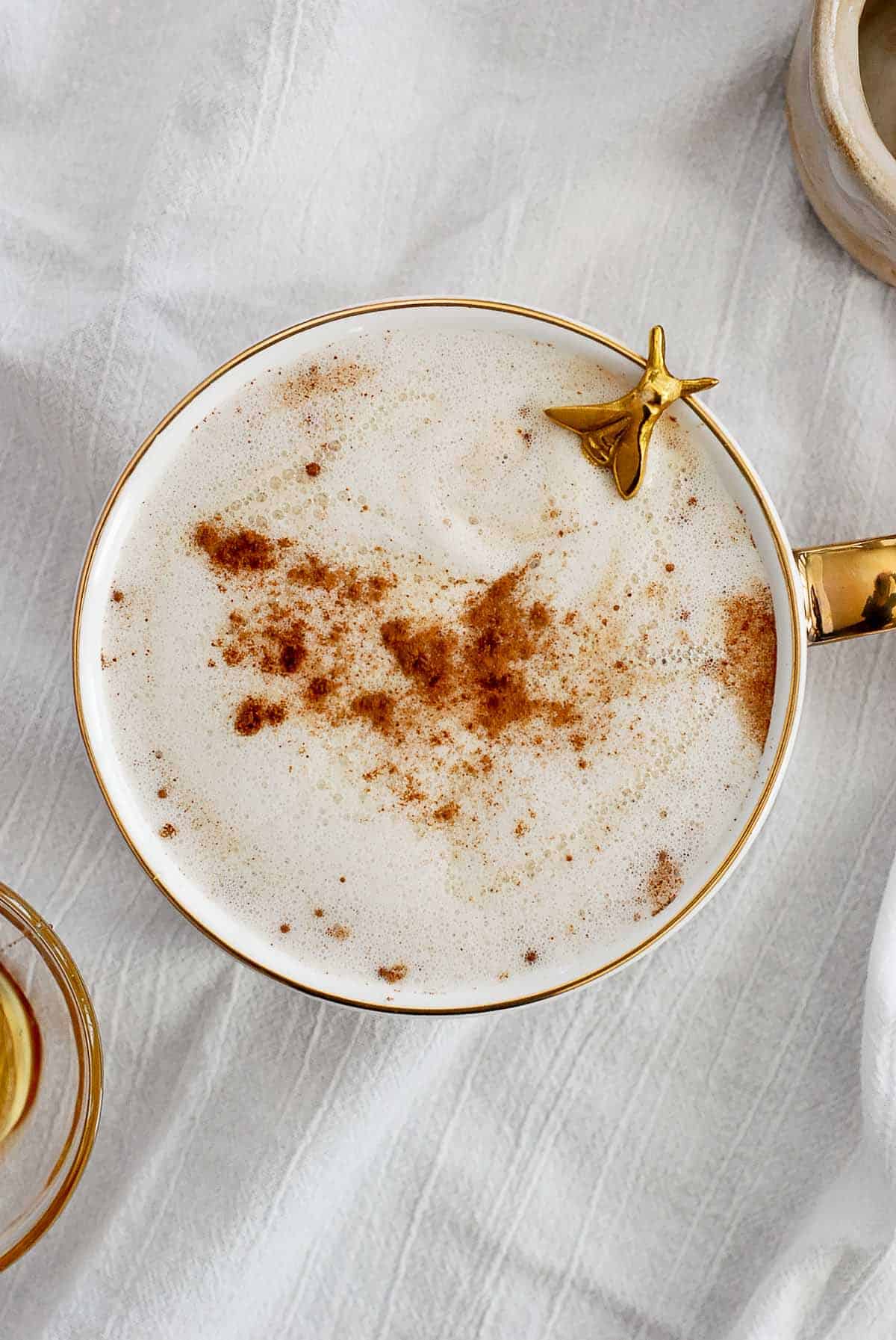 honey oatmilk latte in mug with spoon peeking out.