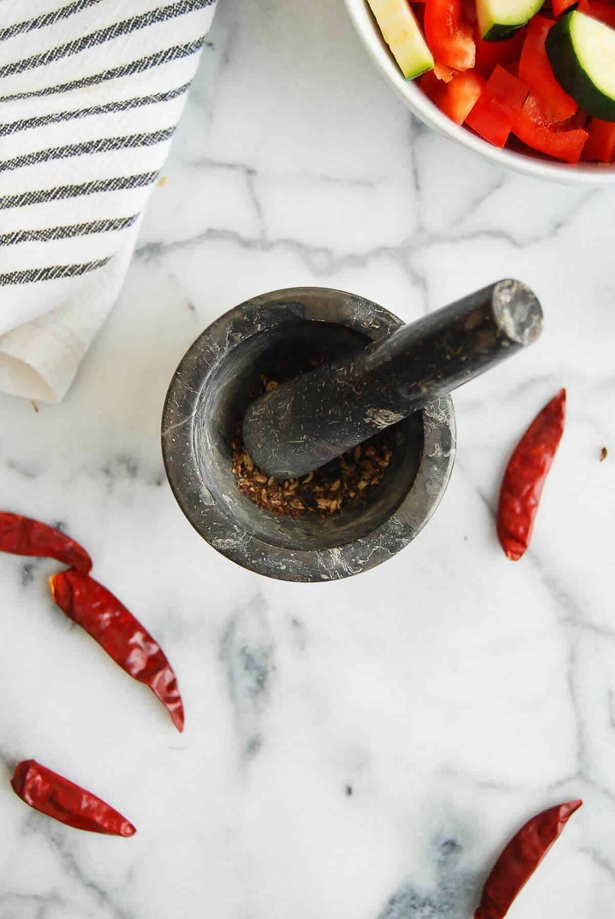 ground sichuan peppercorns in mortar and pestle.