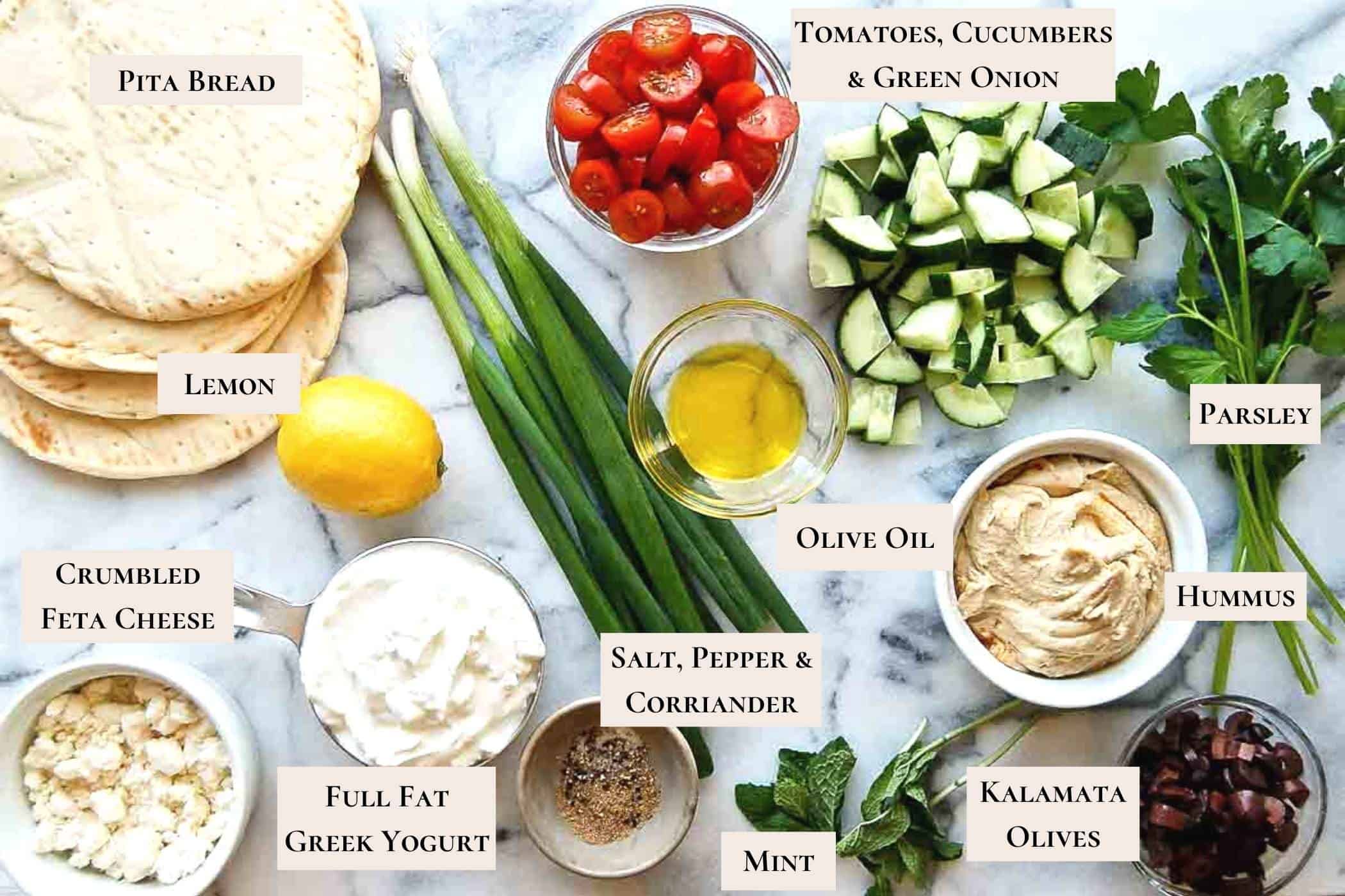 7 Layer Greek Dip Ingredients arranged on cutting board.