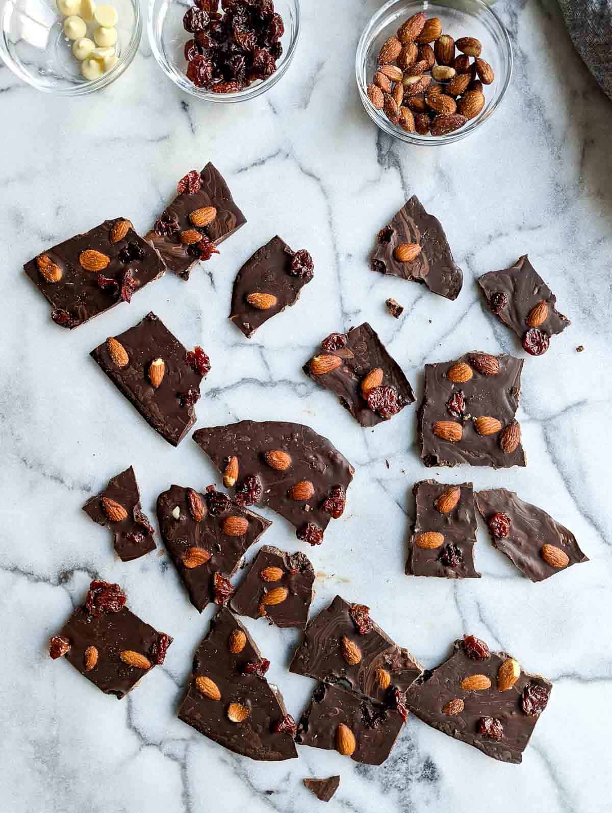 chocolate bark with cherries and almonds on cutting board.