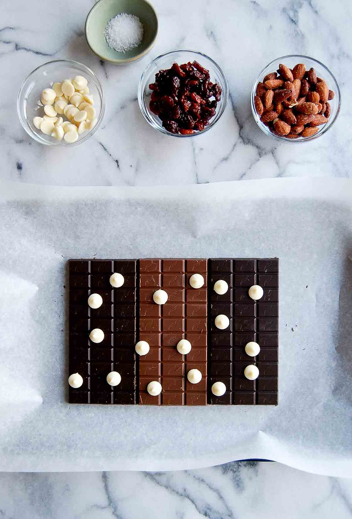 chocolate bars lined up on baking sheet dotted with white chocolate chips.