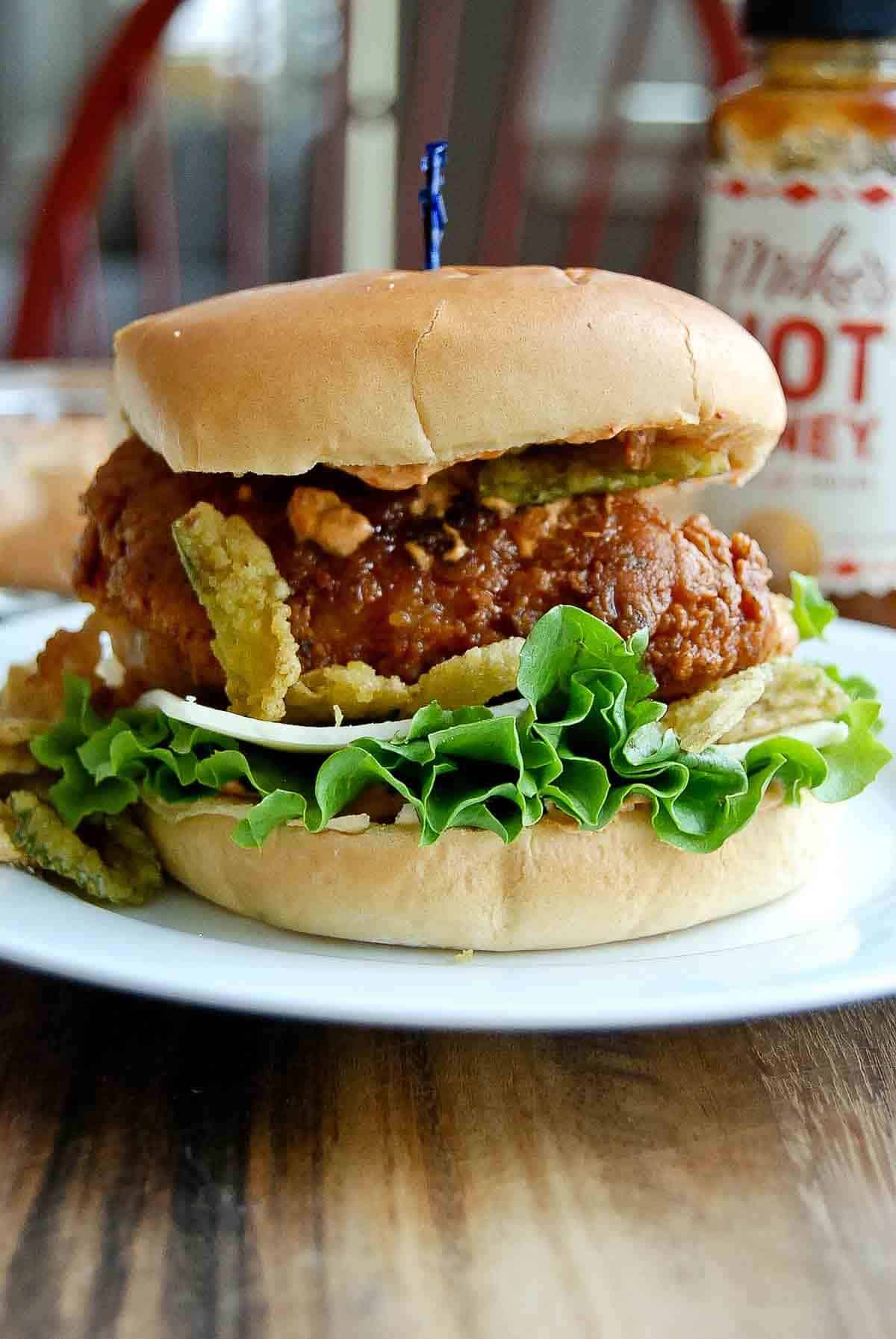 hot honey chicken sandwich on brioche bun on plate.