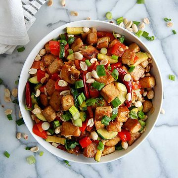 kung pao tofu in bowl on cutting board.