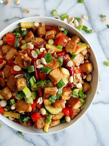 kung pao tofu in bowl on cutting board.