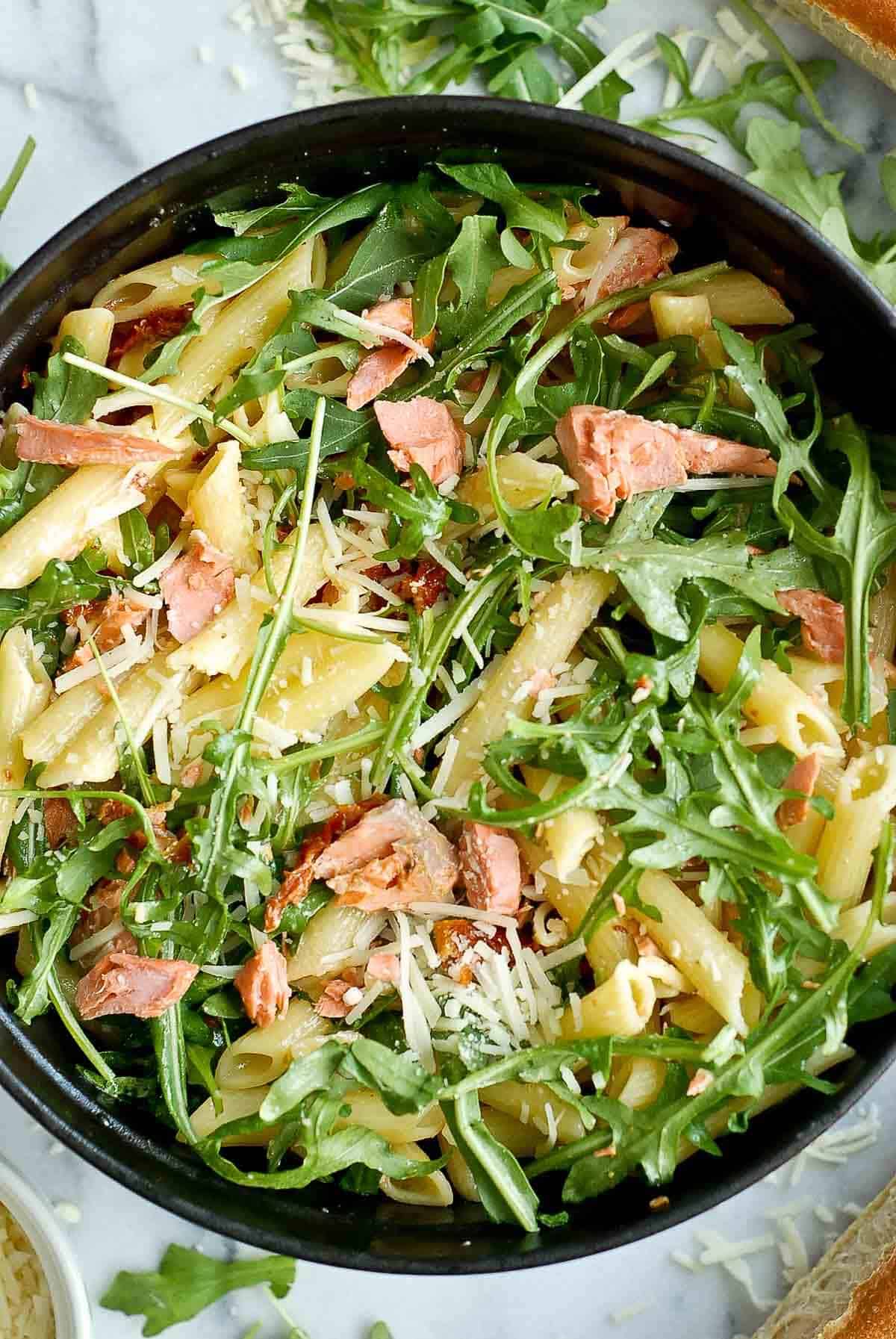 lemon garlic salmon pasta in pot on serving board.