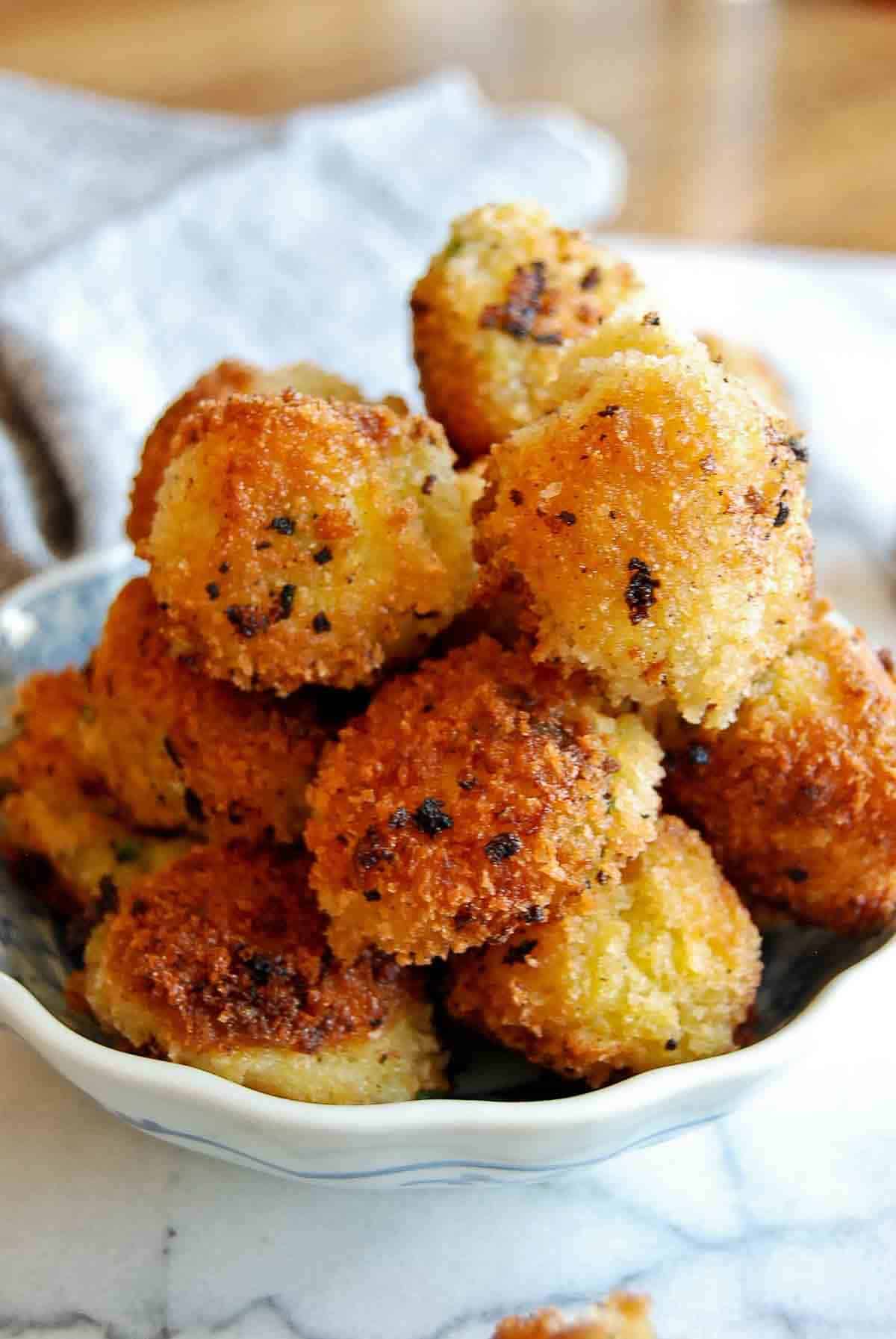 fried mashed potato balls in bowl on counter.