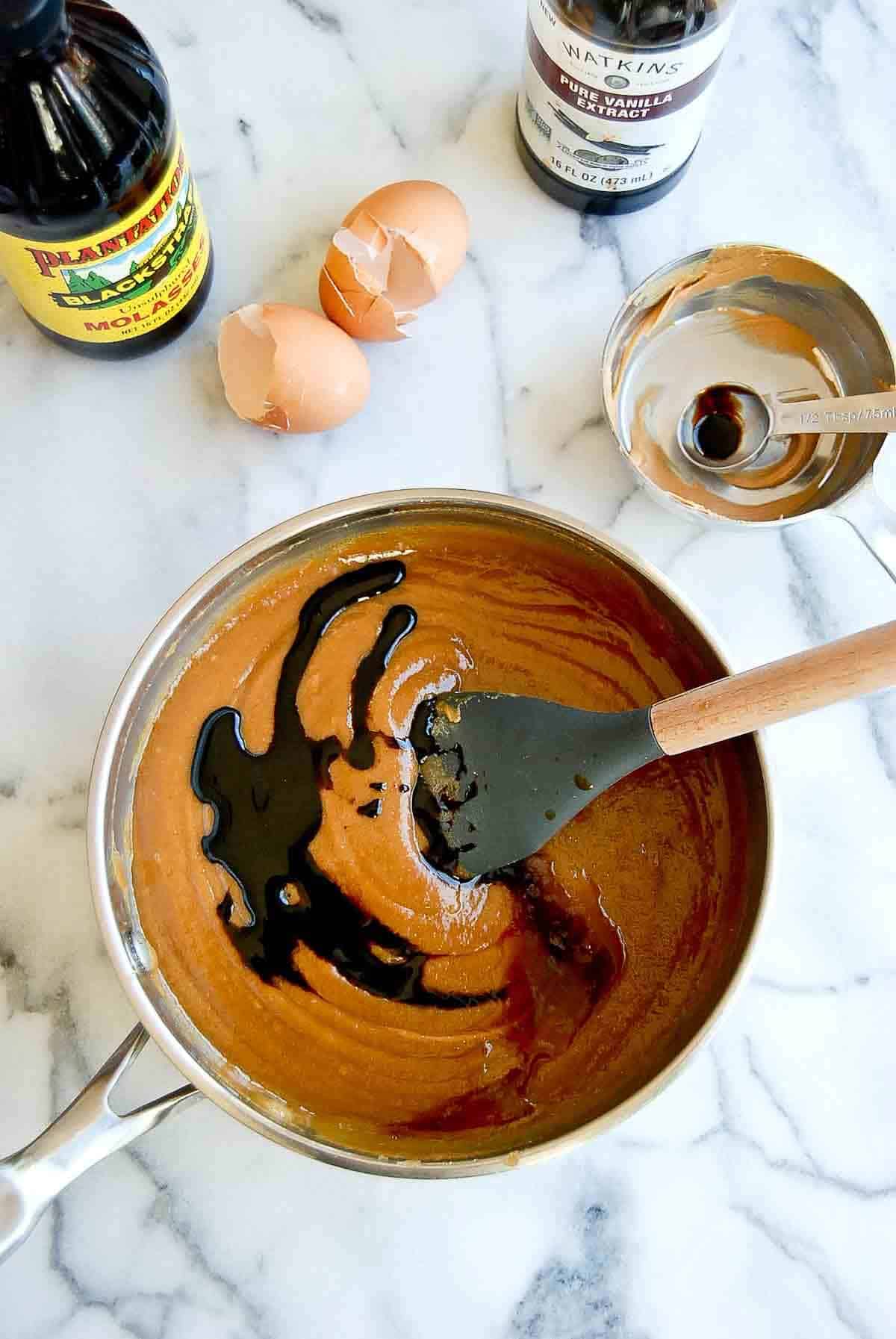 sauce pan combining peanut butter, eggs, vanilla and molasses.