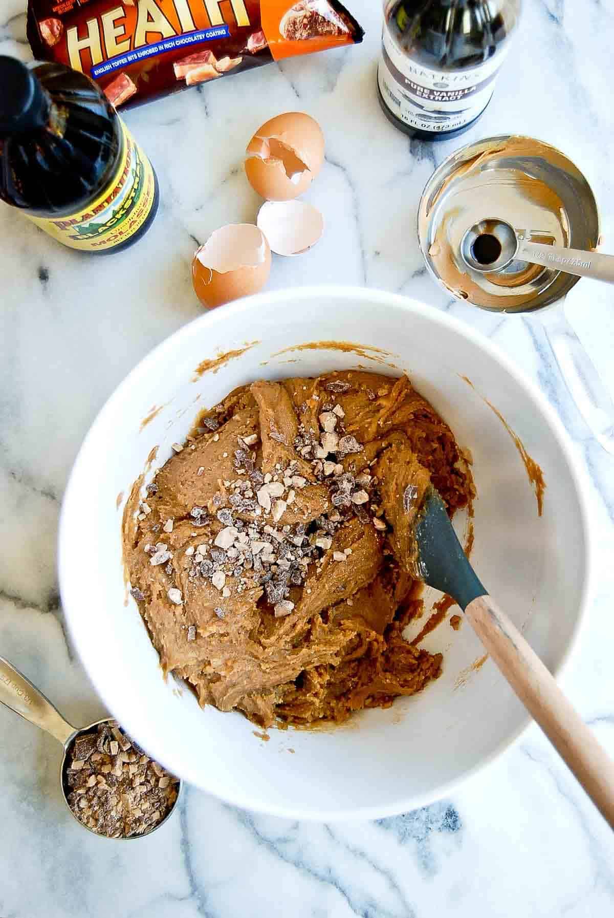 mixing bowl with peanut butter blondie batter and heath bar candies mixed in.