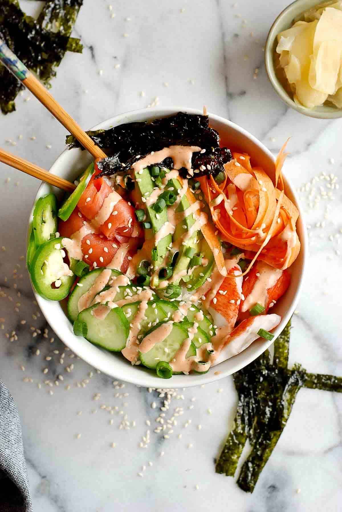 closeup of smoked salmon sushi bowl with chopsticks.