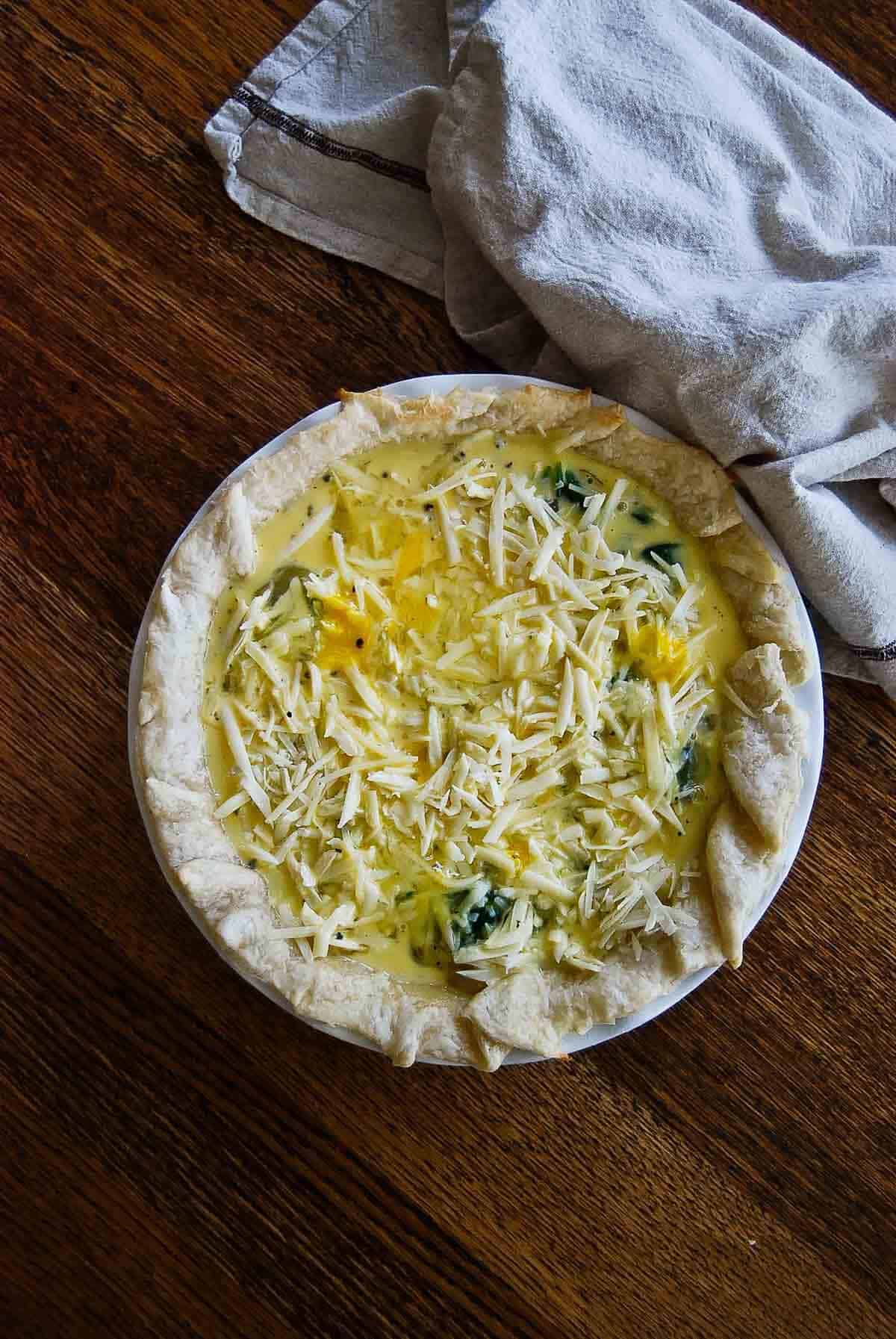 quiche florentine assembled in pie plate.