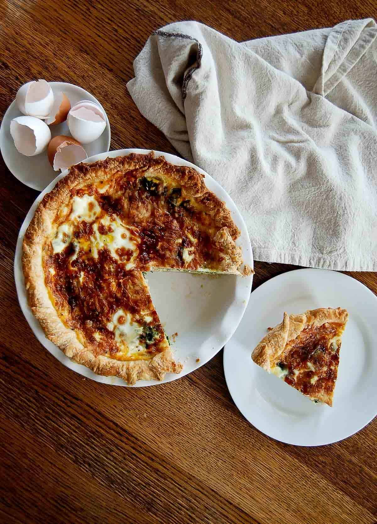 quiche florentine in pie pan with one slice cut out.